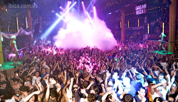 pista de baile de la discoteca Amnesia bajo las luces, llena de gente bailando y coreando al DJ