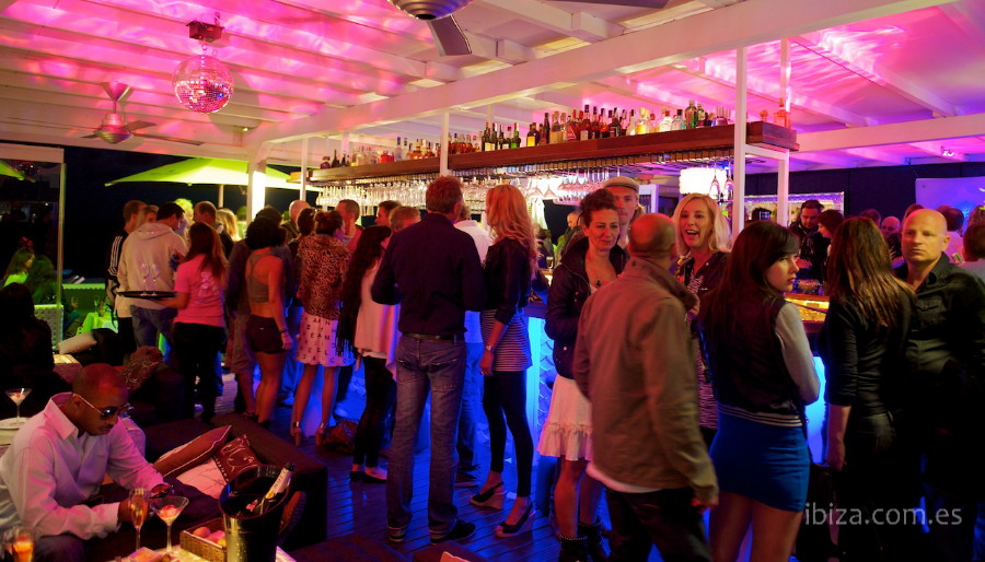 Un grupo de gente brinda y se lo pasa bien en la barra del bar en Playa d'en Bossa
