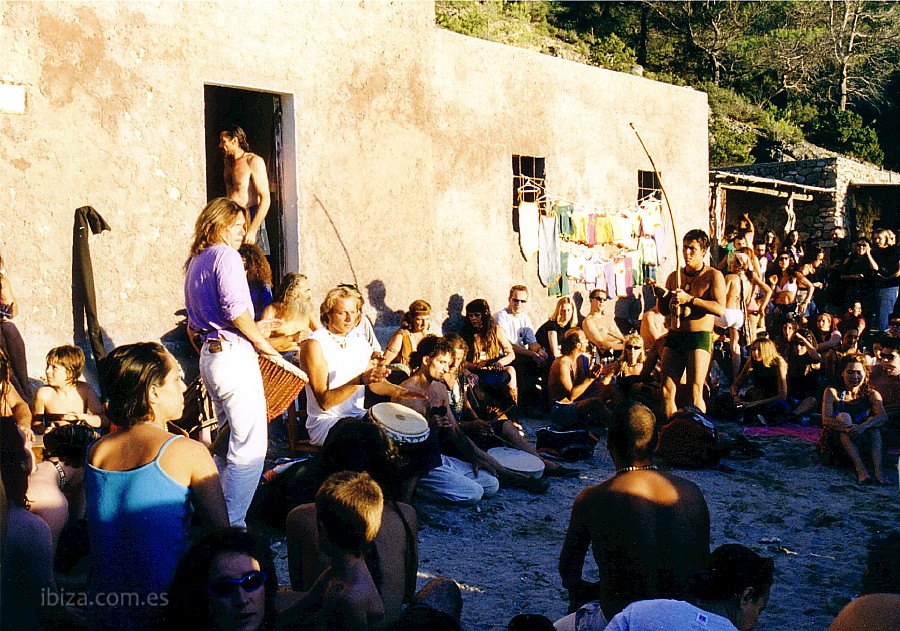Grupo de gente tocando los tambores en Cala Benirrás al atardecer
