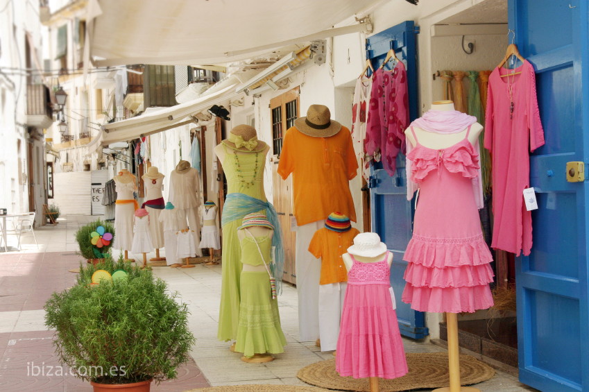 Vestidos de colores se muestran en la calle sobre los maniquís, al exterior de una tienda de Ibiza ciudad