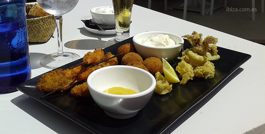 Plato de langostinos rebozados, albondigas de marisco y calamares a la andaluza en el restaurante del Atzaró Beach